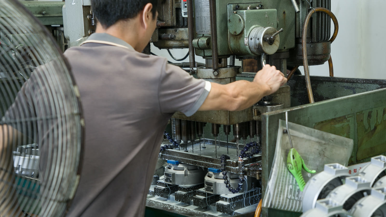 操作人员进行多轴钻孔作业并可见在制工件